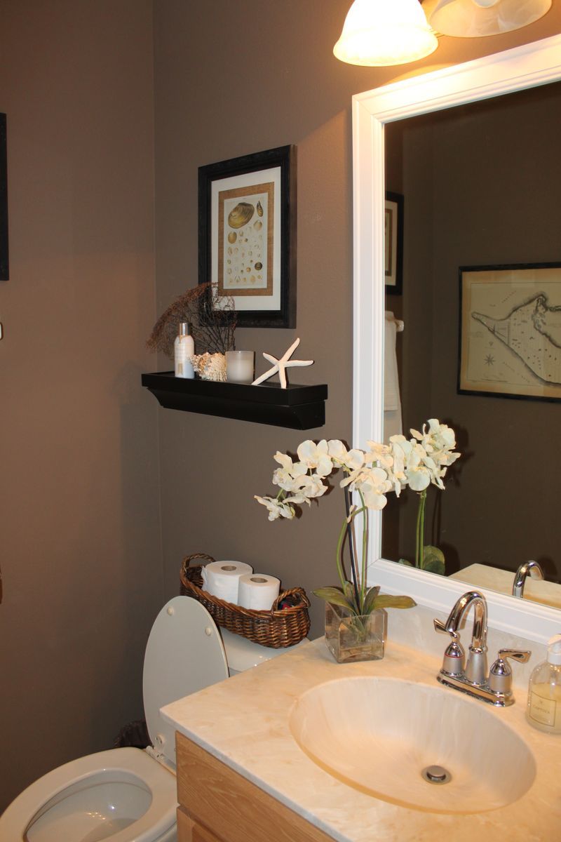 a white toilet sitting next to a bathroom sink under a mirror with