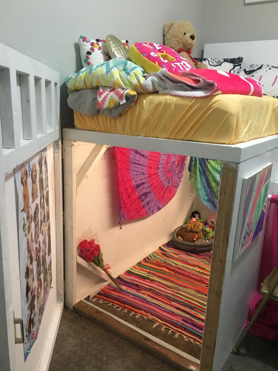 a bunk bed with colorful blankets and pillows on it's bottom shelf next