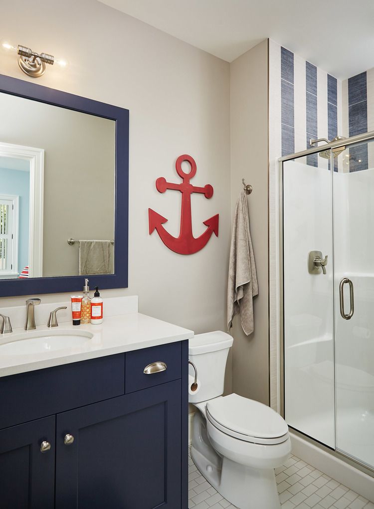 Nautical bathroom in navy and white with red anchor wall decor