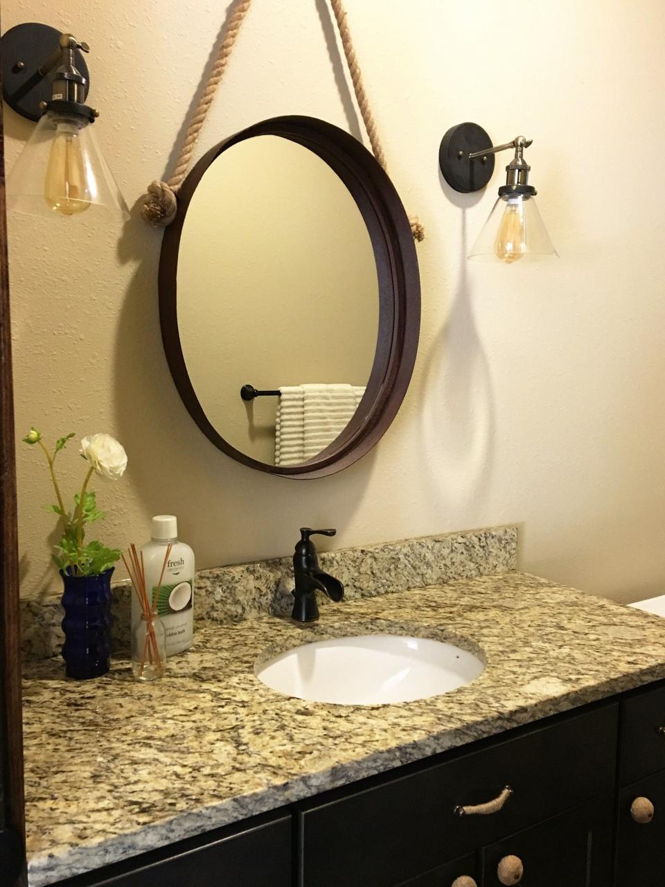 Unique mirror and sconce combo to customize this bathroom. Mirror and